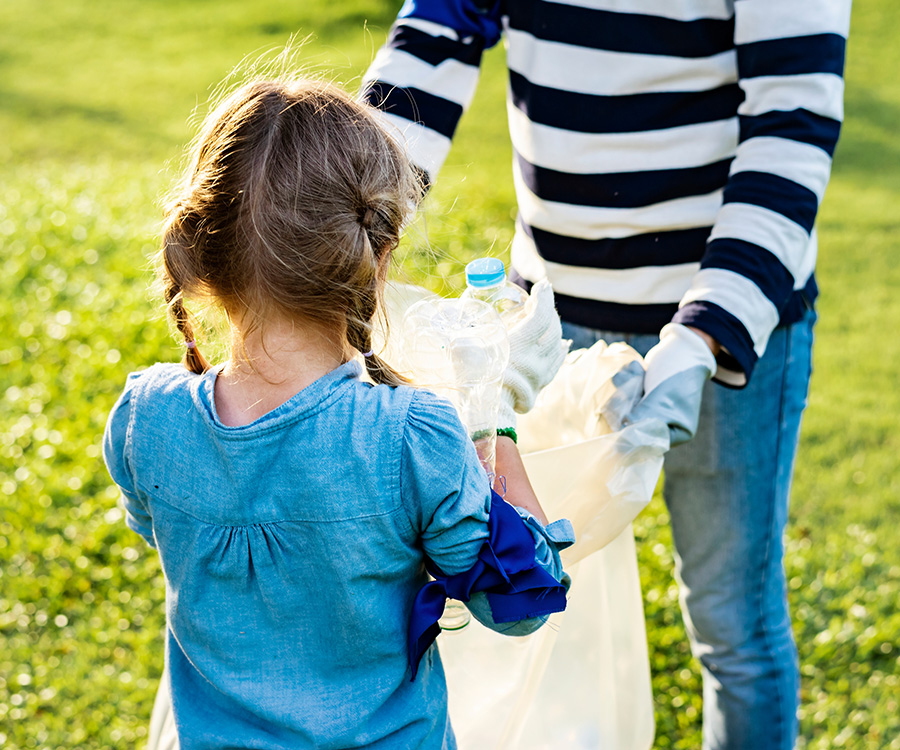 Kind en vrouw ruimen zwerfafval op in het park